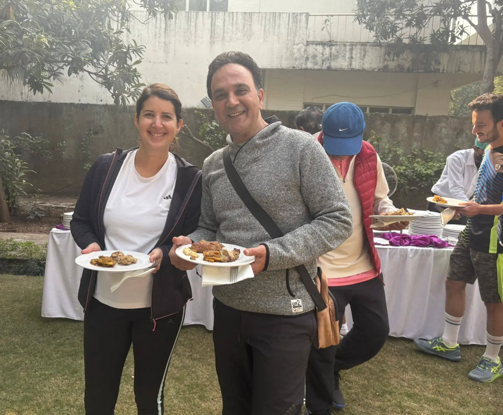 Two members holding plates at the club barbecue lunch